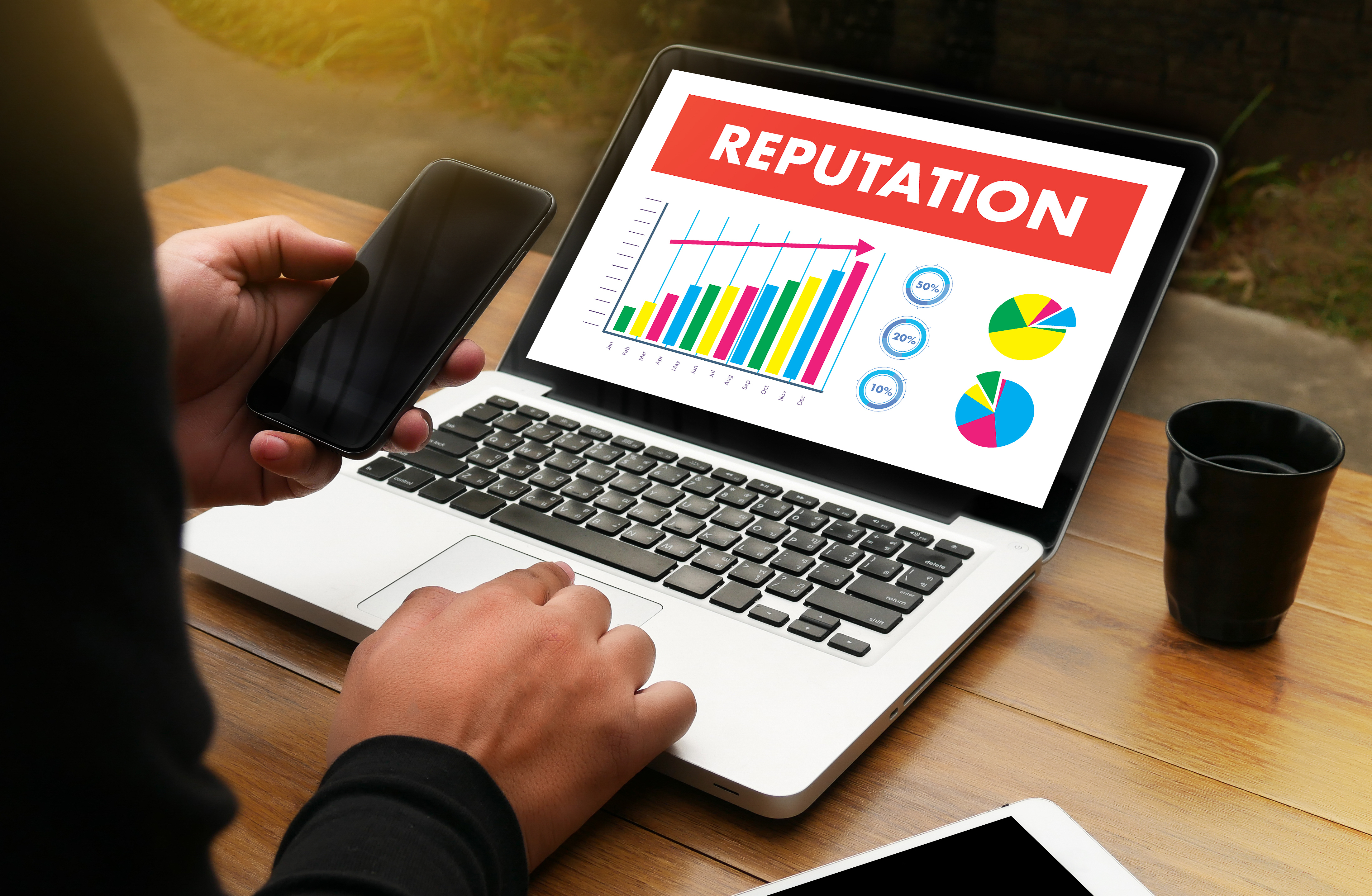 A laptop with 'reputation' and explanation on social media & internet impact on business reputation